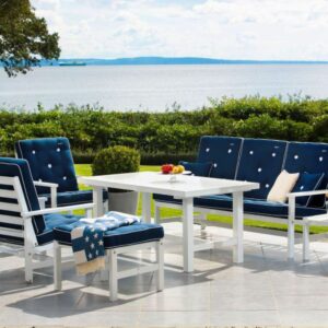 Trädgårdsmiljö med Fri Forms klassiska soffgrupp i vit aluminium och blå dynor.