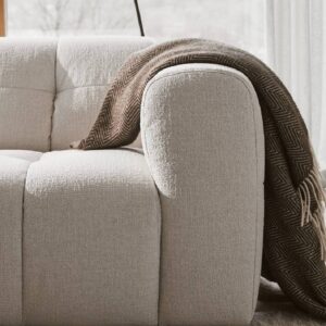 Närbild på armstöd på soffan Åre. Miljöbild på soffa i beige tyg. Tillverkad av Vilmers.