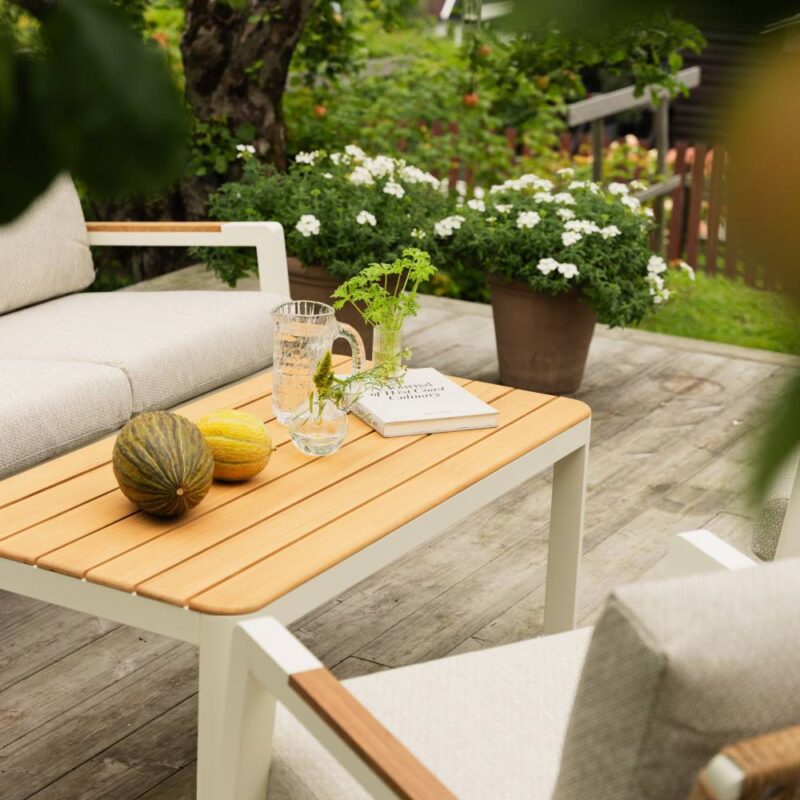 Verona utegrupp i beige aluminium med detaljer i teak och rep. Miljöbild.